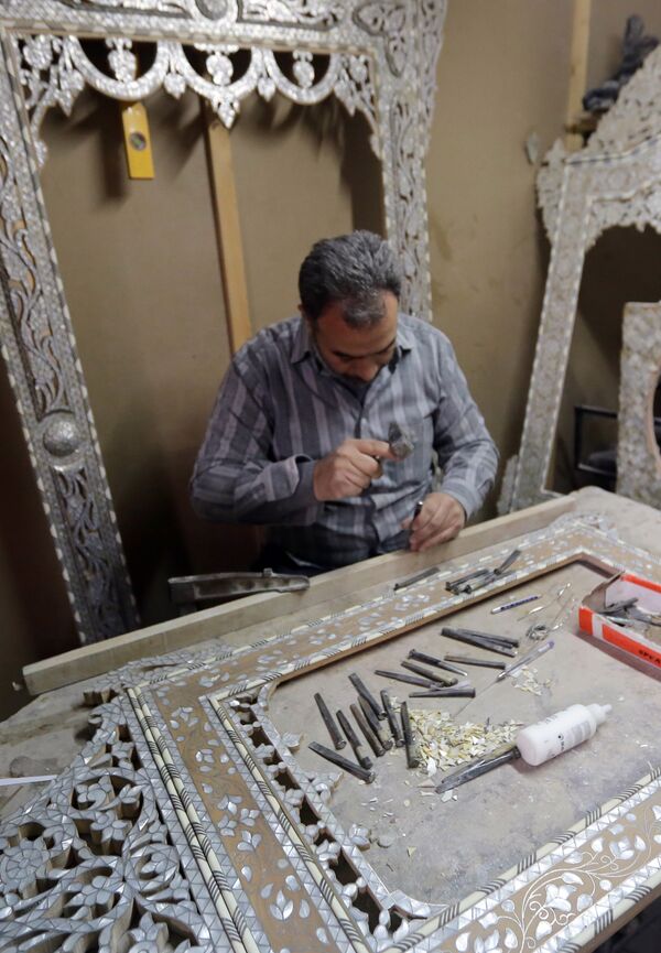 A Syrian artisan etches away at wooden panels inlaid with mother-of-pearl, at a workshop in the capital, Damascus A Syrian artisan etches away at wooden panels inlaid with mother-of-pearl, at a workshop in the capital, Damascus - Sputnik International