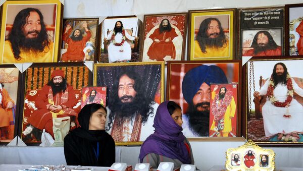 This file photo taken on December 14, 2014 shows Indian followers of deceased guru Ashutosh Maharaj sitting in front of posters bearing his image at a stall during a congregation at his ashram - Sputnik International