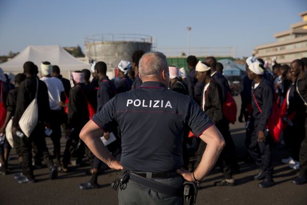 An Italian border police officer escorts sub Saharan men on their way to a relocation center, after arriving in the Golfo Azzurro rescue vessel at the port of Augusta, in Sicily, Italy, with hundreds of migrants aboard, rescued by members of Proactive Open Arms NGO, on Friday, June 23, 2017 An Italian border police officer escorts sub Saharan men on their way to a relocation center, after arriving in the Golfo Azzurro rescue vessel at the port of Augusta, in Sicily, Italy, with hundreds of migrants aboard, rescued by members of Proactive Open Arms NGO, on Friday, June 23, 2017 - Sputnik International