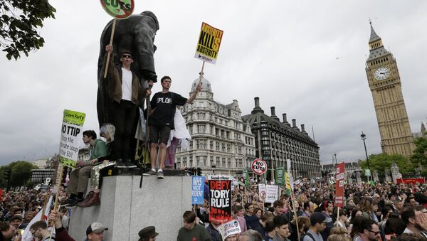 Demonstrators hold placards in Parliament Square as they march during a protest against the Conservative Government and it's austerity policies in London, Saturday, June 20, 2015. - Sputnik International