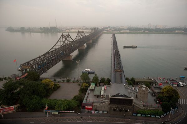The sun sets over the Friendship bridge on the Yalu River connecting the North Korean town of Sinuiju and Dandong in Chinese border city of Dandong on July 5, 2017 - Sputnik International