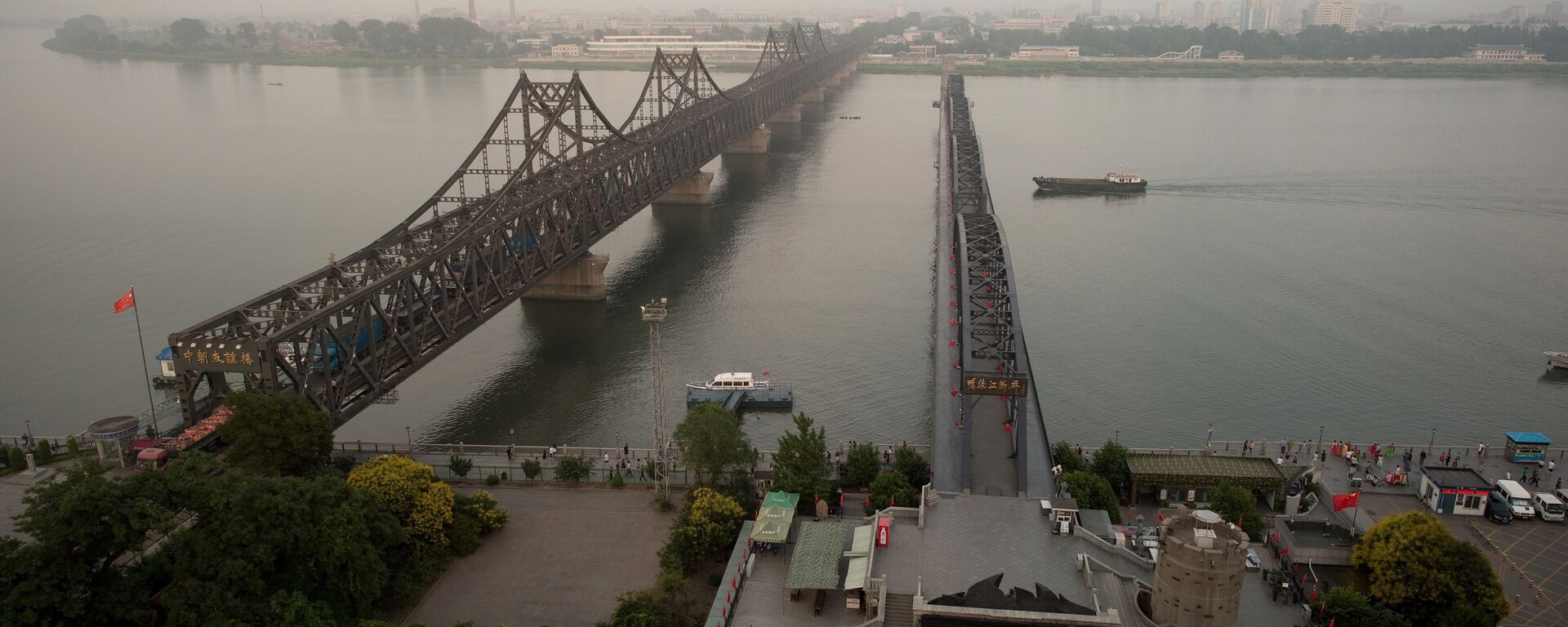 The sun sets over the Friendship bridge on the Yalu River connecting the North Korean town of Sinuiju and Dandong in Chinese border city of Dandong on July 5, 2017 - Sputnik International, 1920, 04.11.2021