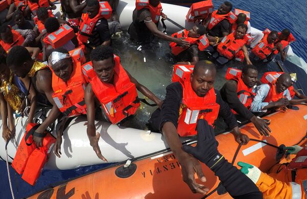 Migrants on a dinghy are rescued by Save the Children NGO crew from the ship Vos Hestia in the Mediterranean sea off Libya coast, June 17, 2017 Migrants on a dinghy are rescued by Save the Children NGO crew from the ship Vos Hestia in the Mediterranean sea off Libya coast, June 17, 2017 - Sputnik International