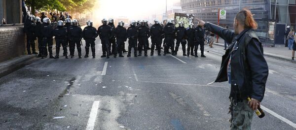 A protester stands in front of German riot police during the demonstrations during the G20 summit in Hamburg, Germany, July 6, 2017 A protester stands in front of German riot police during the demonstrations during the G20 summit in Hamburg, Germany, July 6, 2017 - Sputnik International