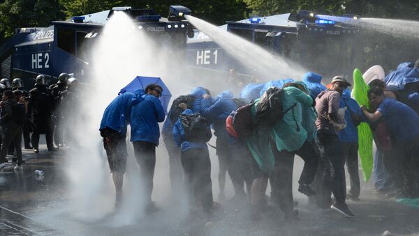 Police uses a water canon while demonstrators block a street during protests against the G-20 summit in Hamburg, Germany, Friday, July 7, 2017 - Sputnik International