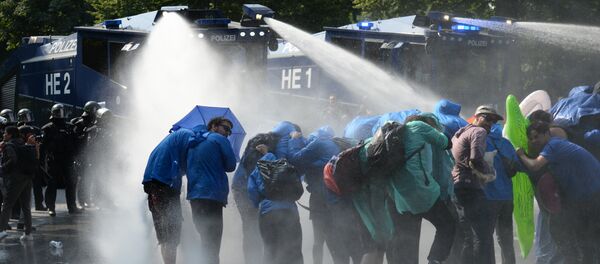 Police uses a water canon while demonstrators block a street during protests against the G-20 summit in Hamburg, Germany, Friday, July 7, 2017 Police uses a water canon while demonstrators block a street during protests against the G-20 summit in Hamburg, Germany, Friday, July 7, 2017 - Sputnik International