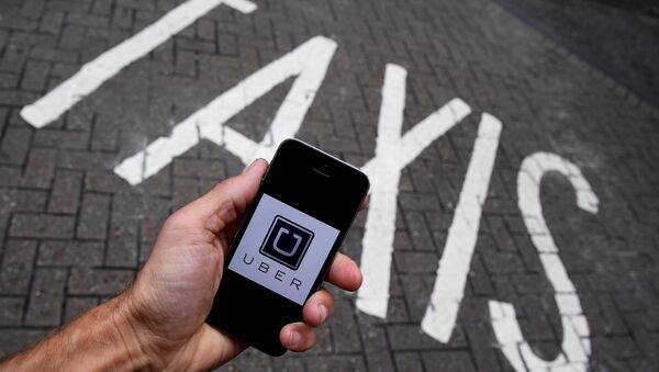 A photo illustration shows the Uber app logo displayed on a mobile telephone. (File) - Sputnik International
