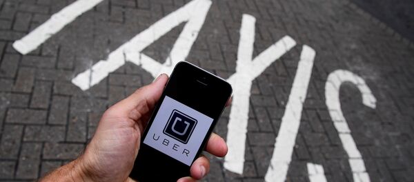 A photo illustration shows the Uber app logo displayed on a mobile telephone. (File) A photo illustration shows the Uber app logo displayed on a mobile telephone. (File) - Sputnik International