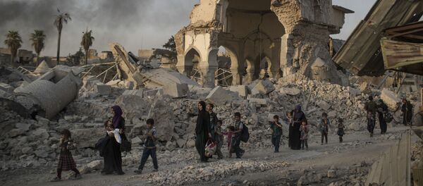 Fleeing Iraqi civilians walk past the heavily damaged al-Nuri mosque as Iraqi forces continue their advance against Islamic State militants in the Old City of Mosul, Iraq, Tuesday, July 4, 2017 - Sputnik International