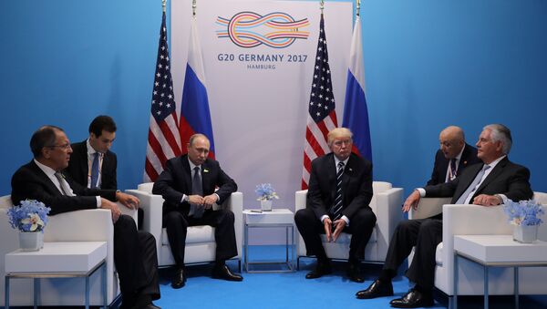 Russia's President Vladimir Putin sits next to U.S. President Donald Trump during their bilateral meeting at the G20 summit in Hamburg, Germany July 7, 2017 - Sputnik International