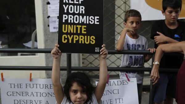 A girl hold up a board with a peace massage during a peace protest at Ladras or Lokmachi crossing point that connects the Greek Cypriot south and the Turkish Cypriots breakaway north, inside the U.N buffer zone in central divided capital , Nicosia, Cyprus, Thursday, July 6, 2017. - Sputnik International