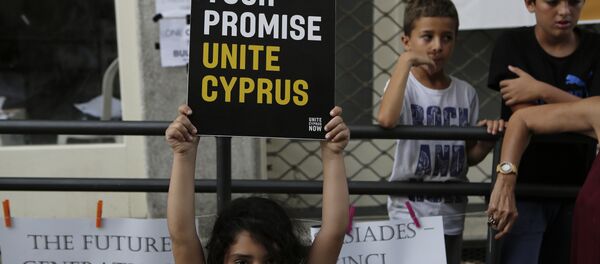 A girl hold up a board with a peace massage during a peace protest at Ladras or Lokmachi crossing point that connects the Greek Cypriot south and the Turkish Cypriots breakaway north, inside the U.N buffer zone in central divided capital , Nicosia, Cyprus, Thursday, July 6, 2017. - Sputnik International