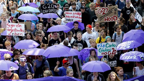 People hold banners and umbrellas as they walk during the protest demonstration at the G20 summit in Hamburg, Germany, July 7, 2017 - Sputnik International