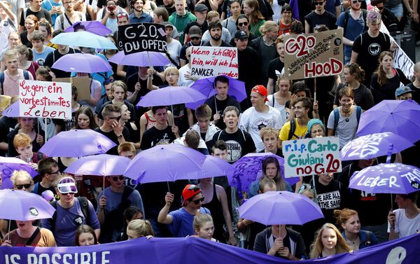 People hold banners and umbrellas as they walk during the protest demonstration at the G20 summit in Hamburg, Germany, July 7, 2017 - Sputnik International