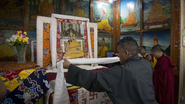 An exile Tibetan government official offers a ceremonial scarf 'khatag' in front of a portrait of his spiritual leader the Dalai Lama to mark the Tibetan leader's 82nd birthday in Dharmsala, India, Thursday, July 6, 2017 - Sputnik International