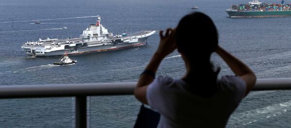 An onlooker takes a photo as China's aircraft carrier Liaoning sails into Hong Kong, China July 7, 2017 An onlooker takes a photo as China's aircraft carrier Liaoning sails into Hong Kong, China July 7, 2017 - Sputnik International