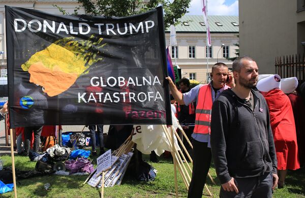 A man stands in front of a banner against U.S. President Trump ahead of his public speech in Warsaw, Poland July 6, 2017 A man stands in front of a banner against U.S. President Trump ahead of his public speech in Warsaw, Poland July 6, 2017 - Sputnik International