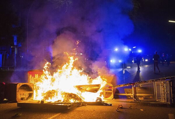 Policemen stand behind a burning barricade in the so-called 'Schanzenviertel' area, on the sidelines of the G-20 summit, early Sunday, July 9, 2017, in Hamburg. Policemen stand behind a burning barricade in the so-called 'Schanzenviertel' area, on the sidelines of the G-20 summit, early Sunday, July 9, 2017, in Hamburg. - Sputnik International