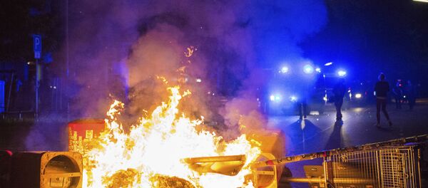 Policemen stand behind a burning barricade in the so-called 'Schanzenviertel' area, on the sidelines of the G-20 summit, early Sunday, July 9, 2017, in Hamburg. - Sputnik International