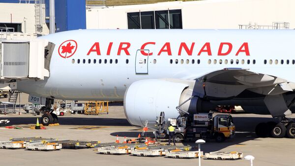An Air Canada Boeing 777 sits at a gate after it was forced to return to Sydney Airport in Sydney, Thursday, July 28, 2011, after crew members saw smoke coming from an oven in the galley. No one on Flight AC34 was injured in the incident, which forced the pilot to dump fuel before safely landing. - Sputnik International