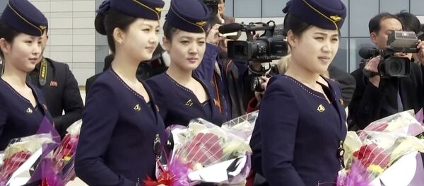 In this image taken from video, Air Koryo cabin crew wait with flowers on tarmac for the airline's first flight from Dandong, at Sunan airport in Pyongyang, North Korea Tuesday, March 28, 2017. - Sputnik International