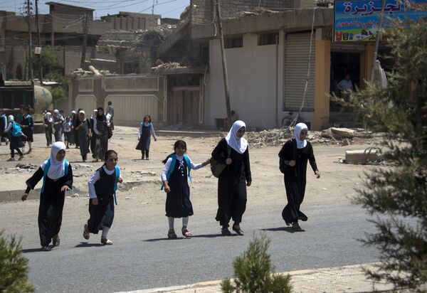 Iraqi girls walk back from school in west Mosul on July 12, 2017 after the government declared it had driven the Islamic State (IS) group jihadists from their one-time top stronghold. - Sputnik International
