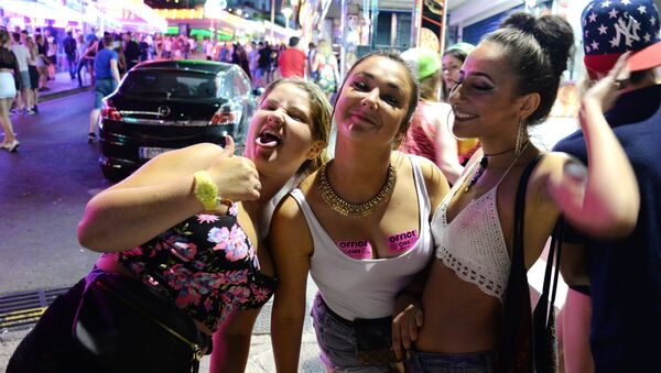 Tourists react as they pose for a photo at the resort of Magaluf, in Calvia town, on the Spanish Balearic island of Mallorca, Wednesday, June 10, 2015. - Sputnik International