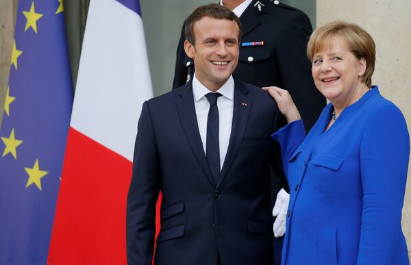 French President Emmanuel Macron (L) accompanies German Chancellor Angela Merkel following a Franco-German joint cabinet meeting at the Elysee Palace in Paris, France, July 13, 2017. French President Emmanuel Macron (L) accompanies German Chancellor Angela Merkel following a Franco-German joint cabinet meeting at the Elysee Palace in Paris, France, July 13, 2017. - Sputnik International