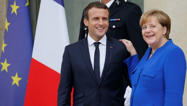 French President Emmanuel Macron (L) accompanies German Chancellor Angela Merkel following a Franco-German joint cabinet meeting at the Elysee Palace in Paris, France, July 13, 2017. - Sputnik International
