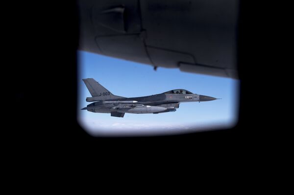 Seen through the window of another aircraft, an Royal Netherlands Air Force F- 16 military fighter jet participating in NATO's Baltic Air Policing Mission operates in Lithuanian airspace during a Ramstein Alloy air force exercise, Tuesday, April 25, 2017 Seen through the window of another aircraft, an Royal Netherlands Air Force F- 16 military fighter jet participating in NATO's Baltic Air Policing Mission operates in Lithuanian airspace during a Ramstein Alloy air force exercise, Tuesday, April 25, 2017 - Sputnik International