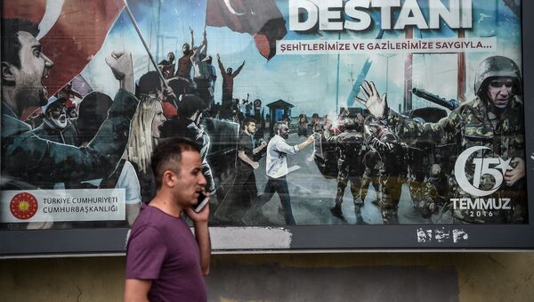 A man at phone walks past a giant billboard reading Legend of July 15 for the anniversary of the last year's attempted coup in Turkey, on July 14, 2017 in Istanbul - Sputnik International