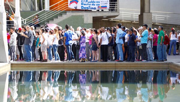 People stand in line to cast their votes at a polling station during an unofficial plebiscite against Venezuela's President Nicolas Maduro's government and his plan to rewrite the constitution, in Caracas, Venezuela July 16, 2017 - Sputnik International