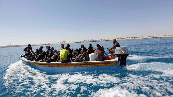 Migrants ride in a boat after they were rescued by Libyan coastguard off the coast of Gharaboli, east of Tripoli, Libya July 8, 2017 - Sputnik International