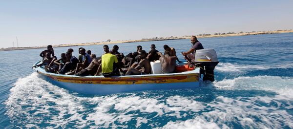 Migrants ride in a boat after they were rescued by Libyan coastguard off the coast of Gharaboli, east of Tripoli, Libya July 8, 2017 - Sputnik International