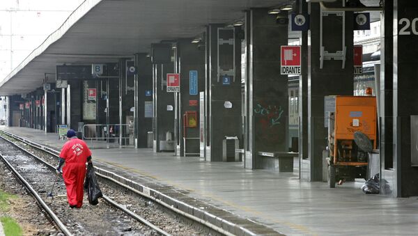 A worker cleans a railway track near an empty platform of the Termini station in Rome. - Sputnik International