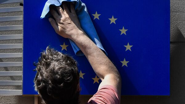 A worker wipes an EU flag clean. - Sputnik International