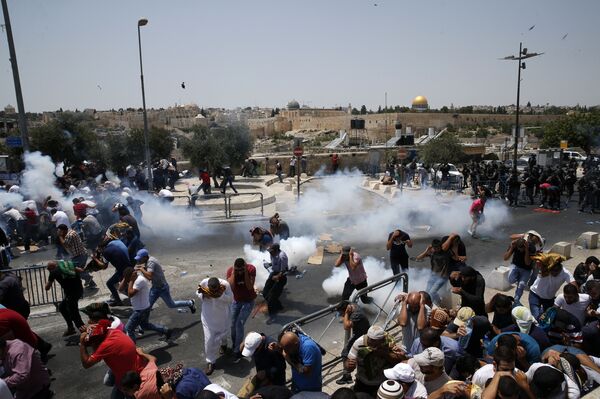 Palestinian worshippers run for cover from teargas, fired by Israeli forces, following prayers outside Jerusalem's Old City in front of the Al-Aqsa mosque compound after Israeli police barred men under 50 from entering the Old City for Friday Muslim prayers as tensions rose and protests erupted over new security measures at the highly sensitive holy site on July 21, 2017. Palestinian worshippers run for cover from teargas, fired by Israeli forces, following prayers outside Jerusalem's Old City in front of the Al-Aqsa mosque compound after Israeli police barred men under 50 from entering the Old City for Friday Muslim prayers as tensions rose and protests erupted over new security measures at the highly sensitive holy site on July 21, 2017. - Sputnik International