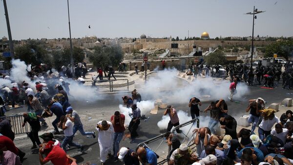 Palestinian worshippers run for cover from teargas, fired by Israeli forces, after prayers outside Jerusalem's Old City in front of the Al-Aqsa mosque compound after Israeli police barred men under 50 from entering the Old City for Friday Muslim prayers as tensions rose and protests erupted over new security measures at the highly sensitive holy site on 21 July 2017.  - Sputnik International