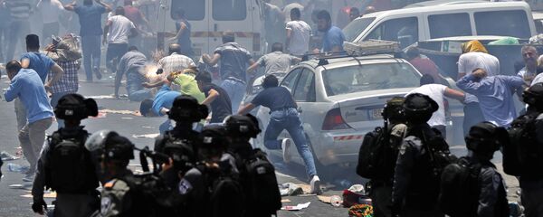 Palestinian worshippers run for cover from teargas, fired by Israeli forces, following prayers outside Jerusalem's Old City in front of the Al-Aqsa mosque compound after Israeli police barred men under 50 from entering the Old City for Friday Muslim prayers as tensions rose and protests erupted over new security measures at the highly sensitive holy site on July 21, 2017. - Sputnik International
