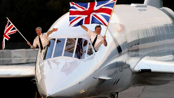 Concorde captain Mike Bannister (R) with the Union Jack flag and senior first officer Jonathan Napier (L) wave as they complete the last supersonic Concorde flight from New York, BA 002, at Heathrow international airport in London 24 October 2003. - Sputnik International