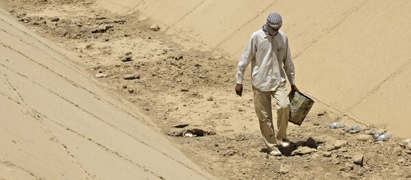 In this photo taken Thursday, July 9, 2009, Abbas Mohammed, walks throw a dray canal in Latifiyah, about 30 kilometers (20 miles) south of Baghdad, Iraq. Below-average rainfall and insufficient water in the Euphrates and Tigris rivers - something the Iraqis have blamed on dams in neighboring Turkey and Syria - have left Iraq bone-dry for a second straight year. In this photo taken Thursday, July 9, 2009, Abbas Mohammed, walks throw a dray canal in Latifiyah, about 30 kilometers (20 miles) south of Baghdad, Iraq. Below-average rainfall and insufficient water in the Euphrates and Tigris rivers - something the Iraqis have blamed on dams in neighboring Turkey and Syria - have left Iraq bone-dry for a second straight year. - Sputnik International