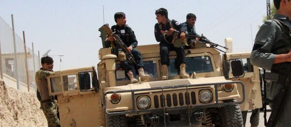 Afghan security personnel sit on atop an armoured vehicles amid an ongoing battle with Taliban militants in the Gereshk district of Helmand province on July 22, 2017 - Sputnik International