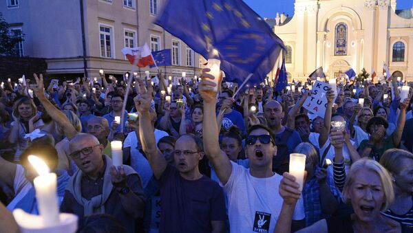 Anti-government protesters raise candles and shout slogans, as they gather in front of the Supreme Court in Warsaw, Poland, Saturday, July 22, 2017 - Sputnik International