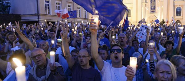 Anti-government protesters raise candles and shout slogans, as they gather in front of the Supreme Court in Warsaw, Poland, Saturday, July 22, 2017 - Sputnik International