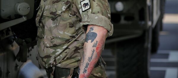 A British serviceman, his arm tattooed with poppies that reads We Will Remember Them stands near vehicles in the Romanian border checkpoint in Giurgiu, Romania, Thursday, June 1, 2017 to take part in the alliance's Noble Jump 2017 exercise which tests the readiness of alliance troops. - Sputnik International