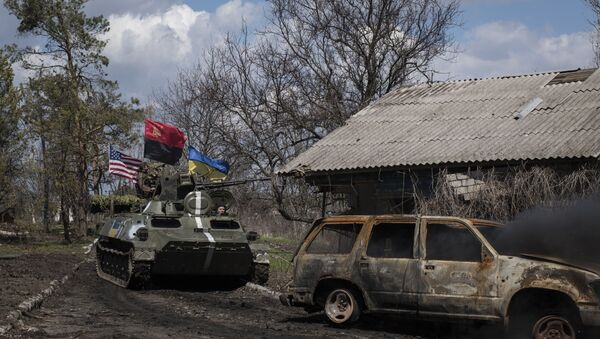 Ukrainian servicemen ride in an armored vehicle, with Ukrainian and U.S. flags and nationalist group Right Sector flag, near a destroyed car in Shyrokyne, eastern Ukraine, Wednesday, April 15, 2015 - Sputnik International