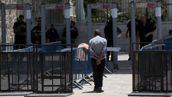 A Palestinian man walks towards a metal detector at the Al Aqsa Mosque compound in Jerusalem's Old City, Wednesday, July 19, 2017 - Sputnik International
