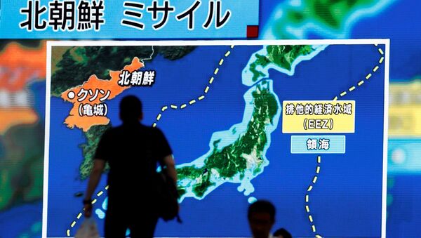 Men walk past a street monitor showing news of North Korea's intercontinental ballistic missile test in Tokyo, Japan. (File) - Sputnik International