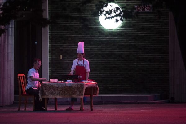 Мужчина ужинает на веранде ресторана в Пхеньяне - Sputnik International