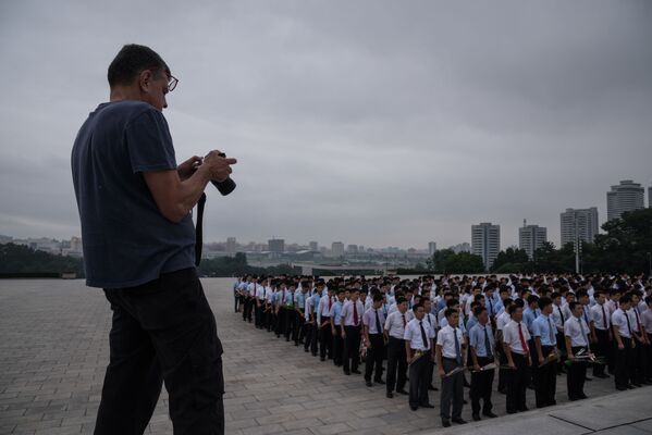 Турист фотографирует группу людей у статуи Ким Ир Сена в Пхеньяне - Sputnik International